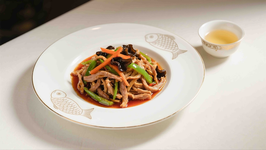 白色的盘子里装着鱼香肉丝有食欲美食美味特色菜川菜