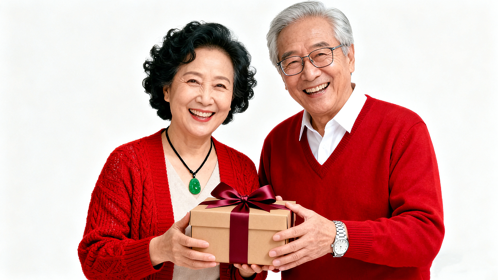 一位穿着红色针织开衫的女士和一位穿着红色毛衣的男士浅棕色礼盒