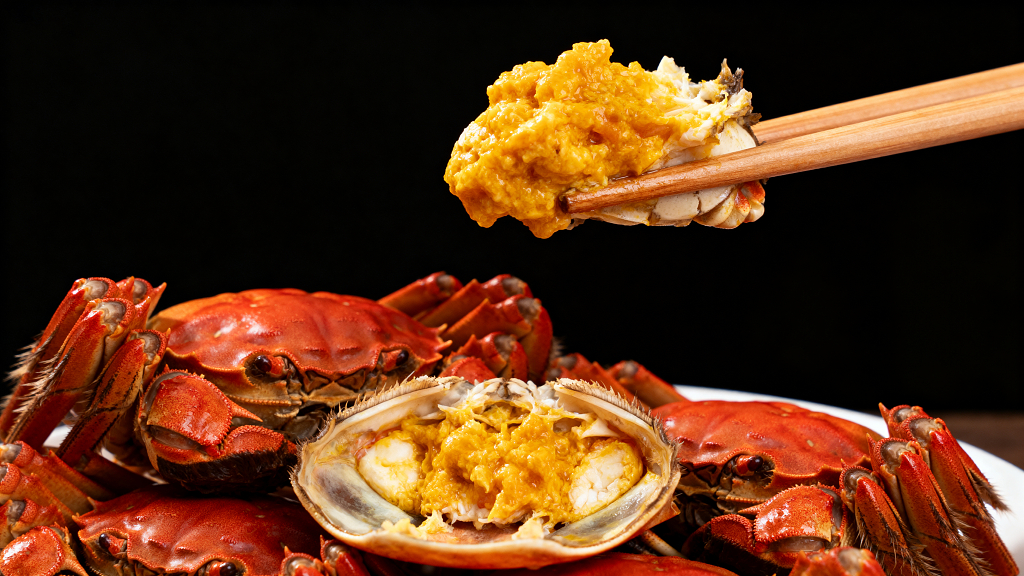 一堆美味的大闸蟹用筷子夹着蟹黄特写