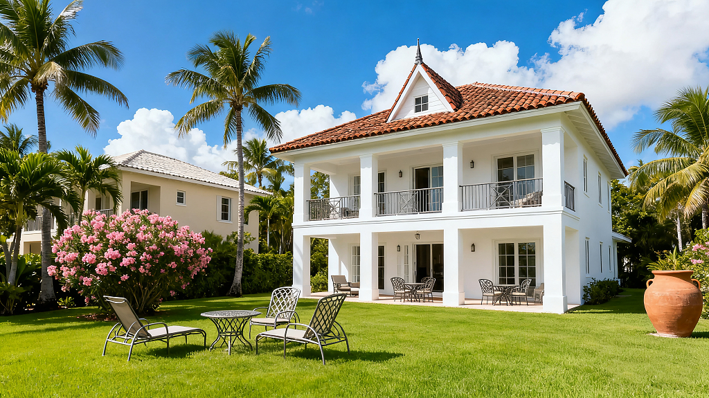 两层白色别墅屋顶铺着棕红色瓦片翠绿的草坪户外家具舒适热带风情