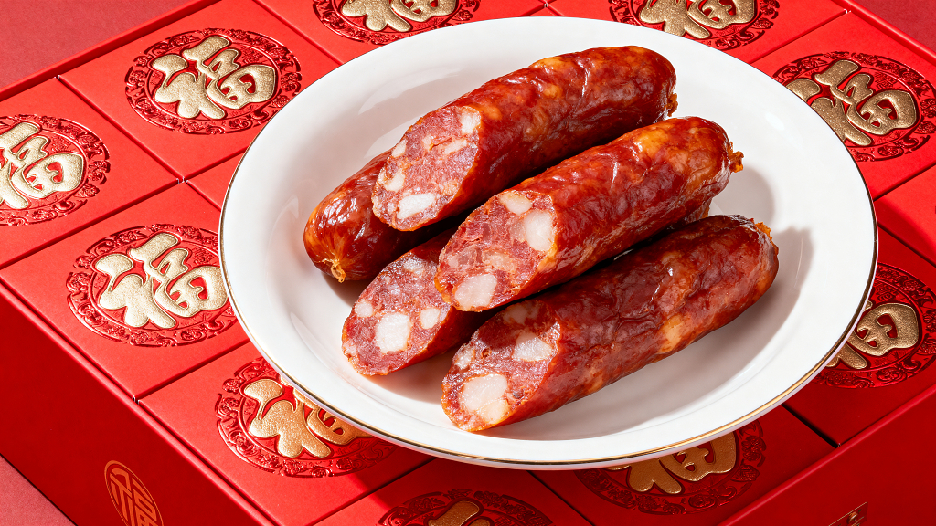 一盘美味的红肠在红色的桌子上