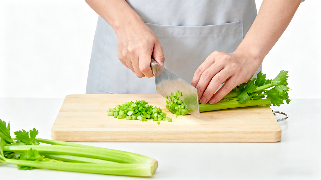 烹饪前食材处理过程穿围裙的人在木质砧板上用菜刀切碎芹菜新鲜