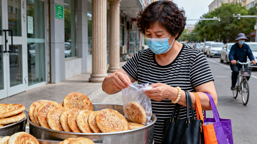 中年女士在路边购买芝麻饼街道商铺为景市井美食消费日常路边摊