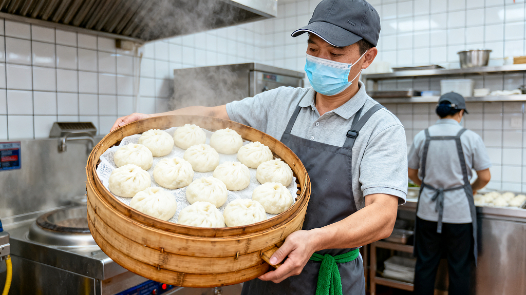 面点师在厨房捧出刚蒸好的包子蒸汽氤氲餐饮职业专业状态蒸汽环绕
