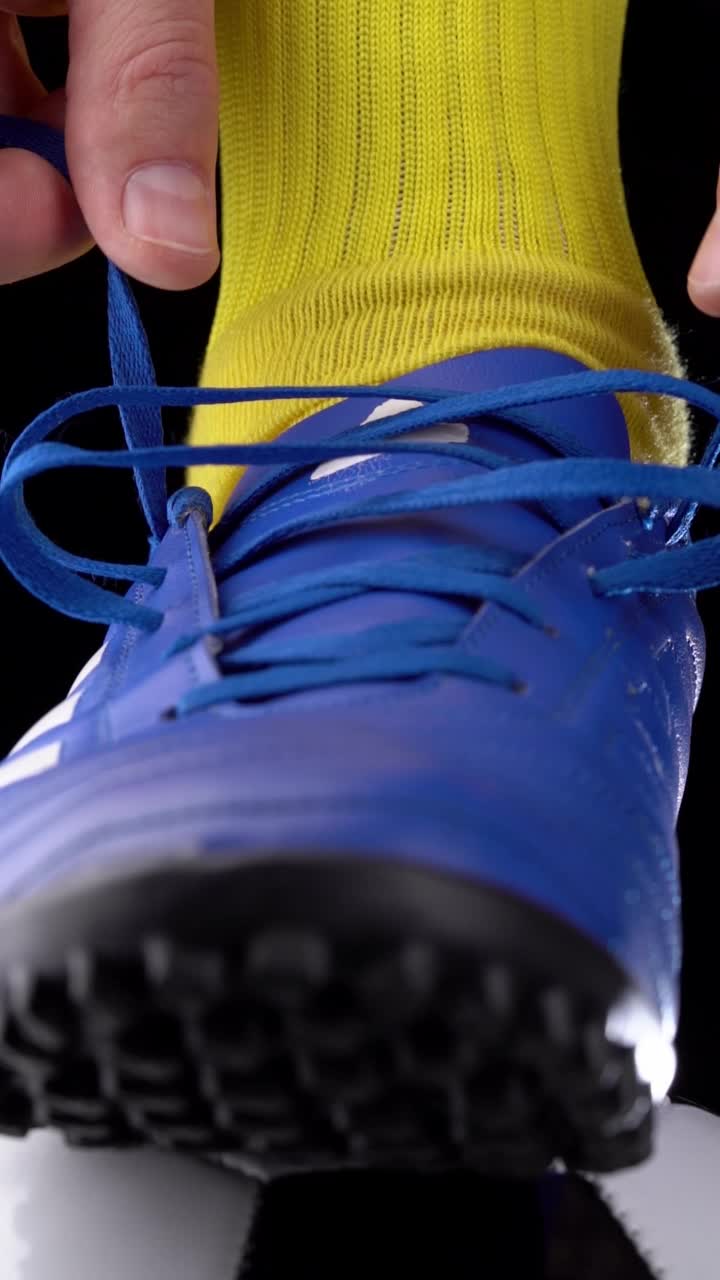 足球运动员系鞋带在足球夹板上，特写，足球世界杯