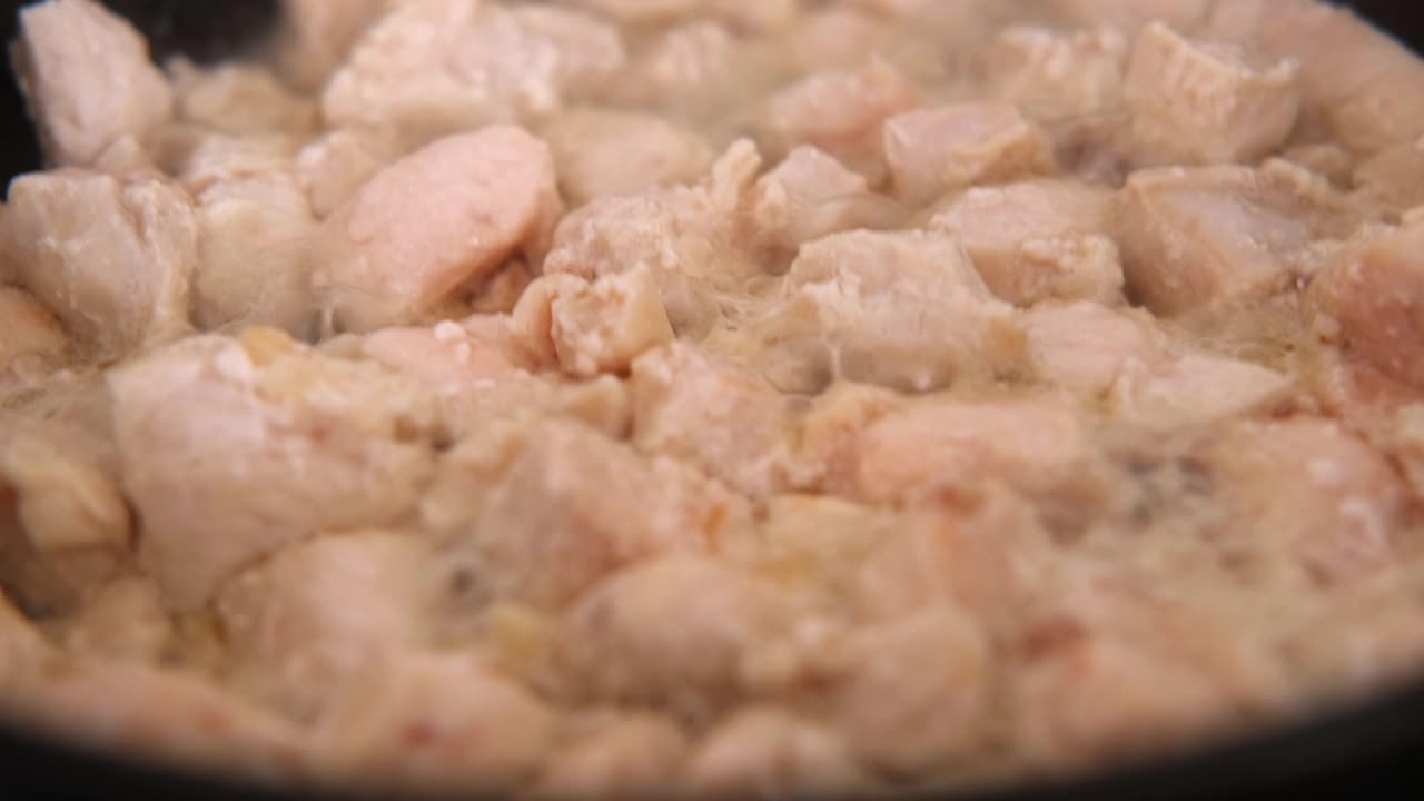 炸碎鸡胸肉，淋上红酱。特写镜头。用黑色煎锅烤鸡柳。炖家禽菜谱。在蒸笼中煮熟的新鲜生白肉。减肥食品，开销