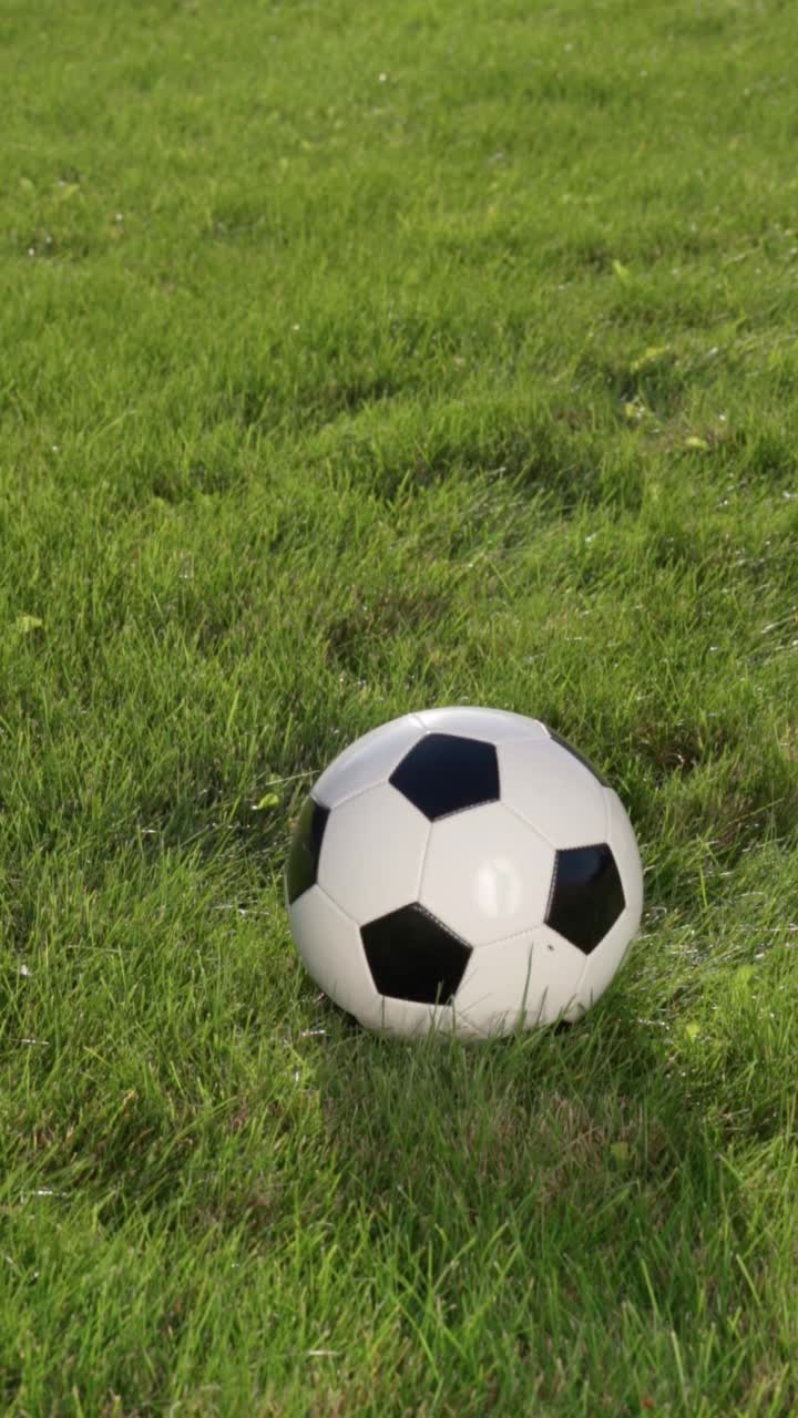 足球运动员的脚和球场草地上的球，慢动作。足球世界杯