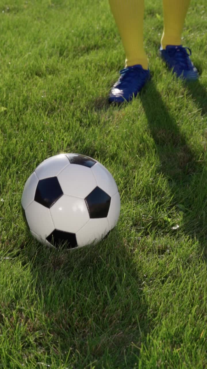 足球运动员的脚和球场草地上的球，慢动作。足球世界杯