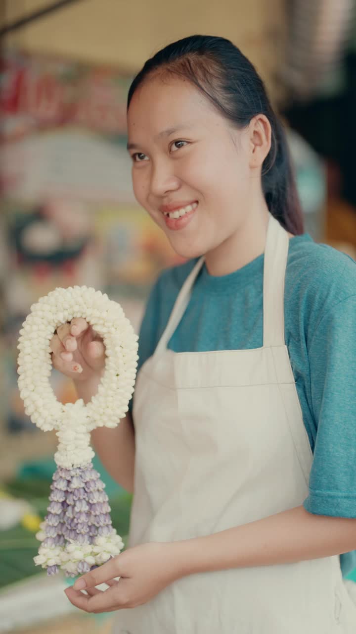 泰国传统文化:微笑的女人在Pak Khlong Talat花卉市场，曼谷。