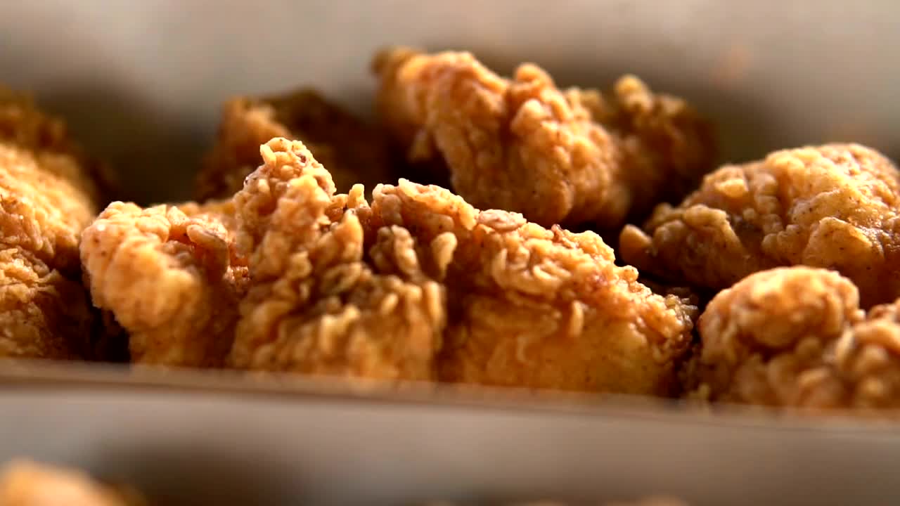 脆炸鸡翅、鸡腿、鸡腿，涂上酱汁。炸酥脆鸡和炸薯条，美味的晚餐