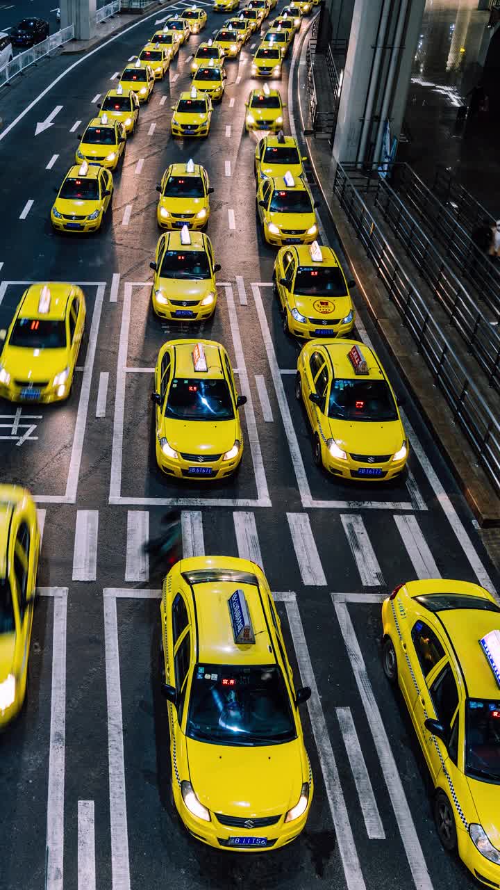 夜间在机场出口排队的黄色出租车