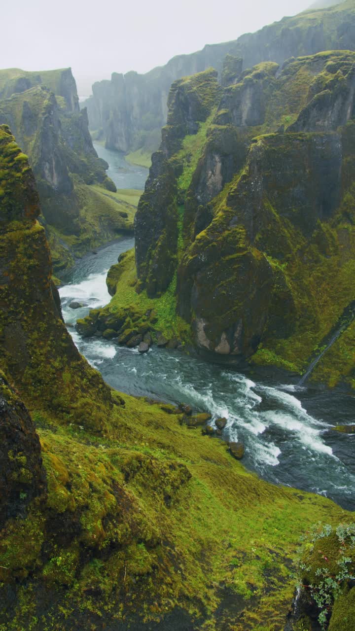 Fjadrargljufur峡谷遭遇暴雨天气。峡谷中崖壁岩层奇异陡峭，河流蜿蜒曲折。冰岛、欧洲