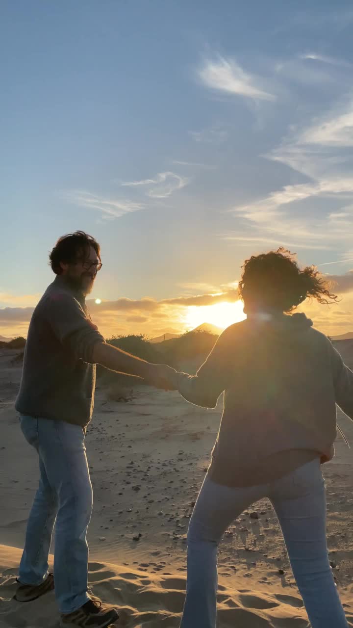 幸福浪漫的成年情侣在沙滩上享受日落，在户外浪漫的休闲活动，一起度过暑假旅游假期。恋爱的人，男人和女人拥抱在一起