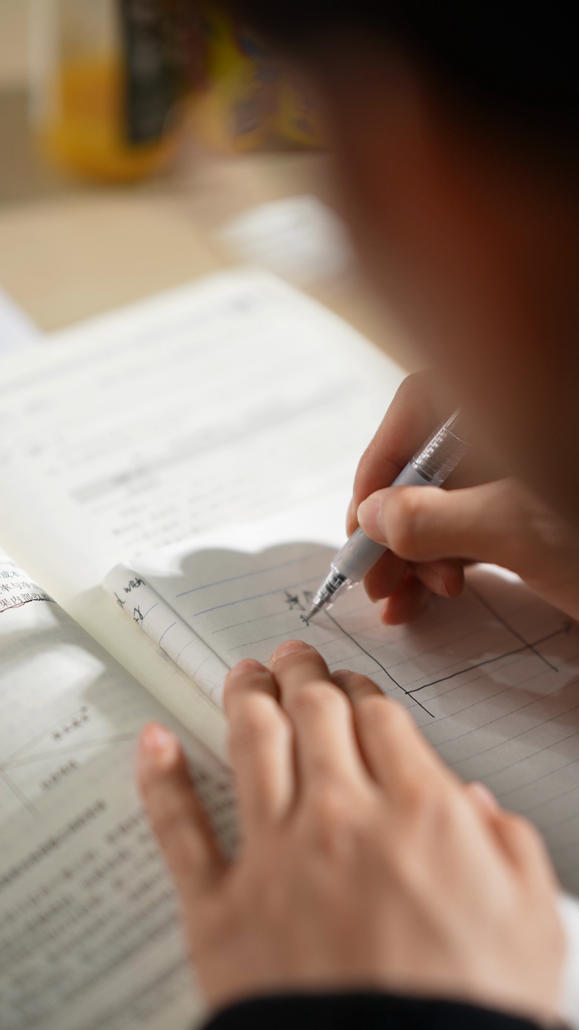 学生一边看题一边解题竖屏认真学习写作业中国教育