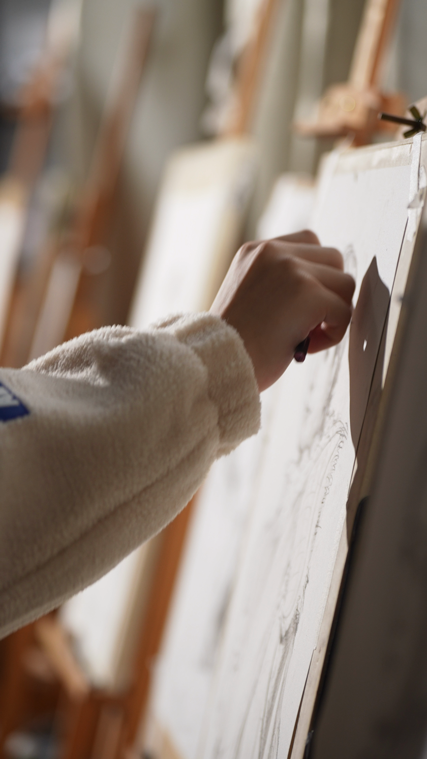 侧面拍摄正在画画的学生