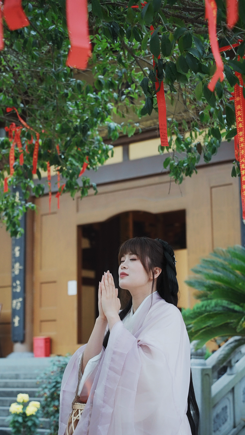 女孩在树下虔诚的祈福